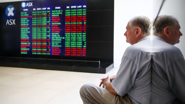 A man looks at an electronic board displaying stock information at the Australian Securities Exchange, operated by ASX Ltd., in Sydney, Australia, on Tuesday, Feb. 6, 2018. Global equity markets are in retreat after Wall Street losses that began in the final session of last week worsened on Monday, with the Dow Jones Industrial Average posting its biggest intraday point drop in history. Photgrapher: Brendon Thorne/Bloomberg Photographer: Brendon Thorne/Bloomberg