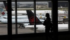 A traveler walks past Air Canada planes at Toronto Pearson International Airport (YYZ) in Toronto. Photographer: Brent Lewin/Bloomberg