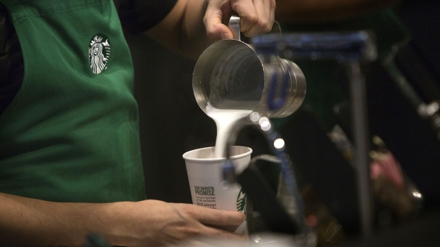 A barista pours frothed milk into a drink inside a Starbucks Corp. coffee shop in New York. Photographer: Victor J. Blue/Bloomberg