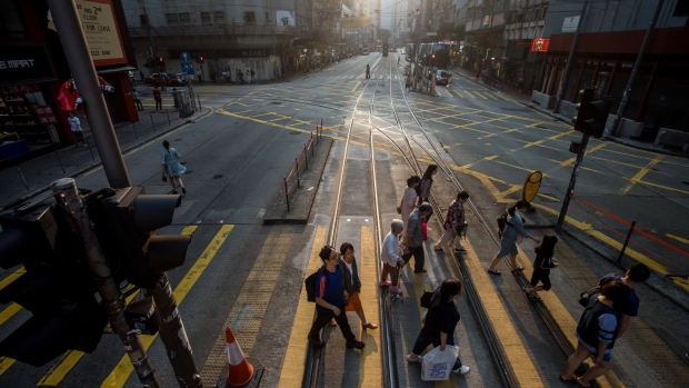 Pedestrians cross a road in the Wan Chai district of Hong Kong, China, on Sunday, Oct. 27, 2019. Hong Kong may report negative growth this year as the economy reels from more than four months of social unrest, Financial Secretary Paul Chan wrote in a blog post. The government will announce its advanced estimate for third-quarter growth on Oct. 31. Photographer: Paul Yeung/Bloomberg