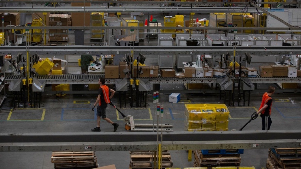 Employees pull carts containing online orders at the Amazon.com Inc. fulfillment center in Robbinsville, New Jersey. 