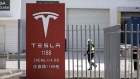 A worker walks past gates at the Tesla Inc. Gigafactory in Shanghai, China, on Monday, Feb. 17, 2020. Tesla has fully resumed deliveries of its China-built model 3 sedans, according to a company representative, after a pause due to the coronavirus outbreak. Photographer: Qilai Shen/Bloomberg