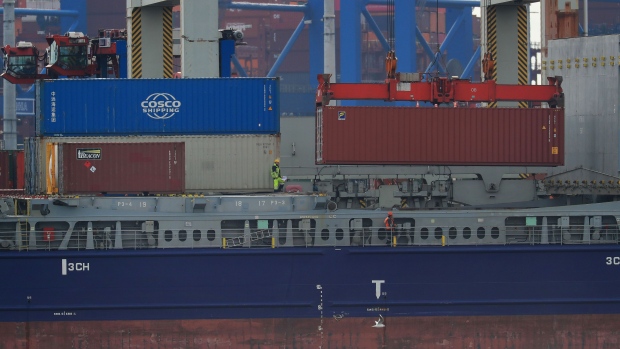A crane lowers shipping containers onto cargo vessel 'Sondeborg', operated by Carsten Rehder Schiffsmakler Und Reederei GmbH, at the port of Hamburg in Hamburg, Germany, on Tuesday, March 3, 2020. As the coronavirus wreaks havoc on physical supply chains and global trade, the shipping industry is rife with canceled voyages, idle containers and falling rates. Photographer: Krisztian Bocsi/Bloomberg
