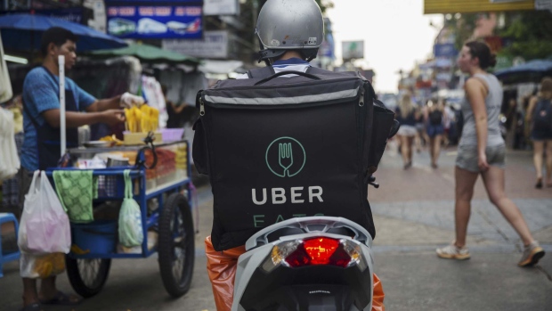 An Uber Technologies Inc. Eats delivery driver rides a motorcycle along a road in Bangkok, Thailand, on Friday, March 9, 2018. Uber Chief Executive Officer Dara Khosrowshahi said growth of the UberEats app was exploding and estimated that it would be the largest food-delivery business in the world this year. Photographer: Brent Lewin/Bloomberg