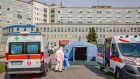 Medical workers stand between ambulances at the pre-triage tent outside a hospital in Cremona, Italy. Photographer: Francesca Volpi/Bloomberg