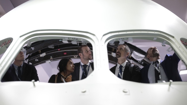 Attendees inspect a passenger aircraft cabin body at the Stelia Aerospace exhibition stand during the 53rd International Paris Air Show at Le Bourget in Paris, France, on Tuesday, June 18, 2019. The show is the world's largest aviation and space industry exhibition and runs from June 17-23. Photographer: Jason Alden/Bloomberg