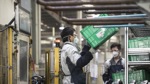 Employees wearing protective face masks work on a production line during a media tour at a Yanfeng Adient Seating Co. factory in Shanghai, China, on Monday, Feb. 24, 2020. Central and local governments are loosening the criteria for factories to resume operations as they walk a tightrope between containing a virus that has killed almost 2,600 people and preventing a slump in the world’s second-largest economy. Photographer: Qilai Shen/Bloomberg