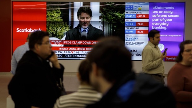 Prime Minister Justin Trudeau is seen on a screen in the financial district of Toronto, Ontario, Canada, on Monday, March 16, 2020. Canadian stocks plunged more than 9% after emergency measures from central banks failed to soothe fears the economy will suffer a heavy blow from the coronavirus. Photographer: Cole Burston/Bloomberg