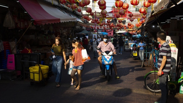 A motorcyclist wearing a protective mask travels through a market in the Chinatown district of Bangkok, Thailand, on Wednesday, Feb. 5, 2020. Thai officials have estimated the damage to tourism at 95 billion baht ($3.1 billion) through April. Thailand’s tourism authority expects the number of visitors from China to fall by at least 2 million. Travel and tourism amount to nearly 10% of Thailand’s GDP. Photographer: Andre Malerba/Bloomberg