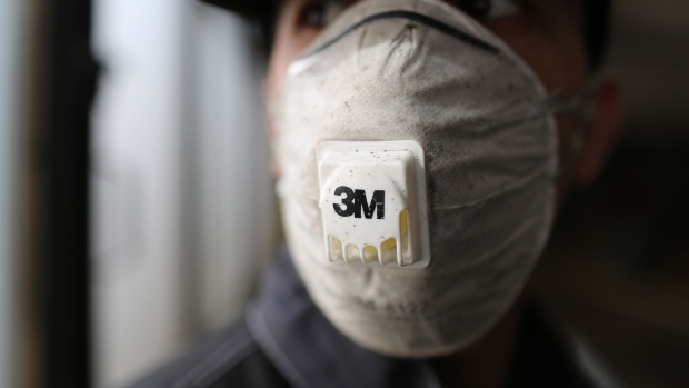 A workers wears a 3M Co. branded protective face mask during a deep-clean of GUP Mosgortrans passenger buses at a service terminal in Moscow, Russia, on Thursday, March 19, 2020. 
