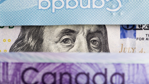 A U.S. one hundred dollar banknote depicting U.S. founding father Benjamin Franklin and Canadian banknotes are arranged for a photograph in Toronto, Ontario, Canada, on Wednesday, July 25, 2018. One of Prime Minister Justin Trudeau's envoys said the government would respond "proportionally" if the U.S. imposes tariffs on vehicles and parts, though Canada hasn't begun preparing any formal retaliatory package, two people familiar with the matter said. Photographer: Bloomberg/Bloomberg