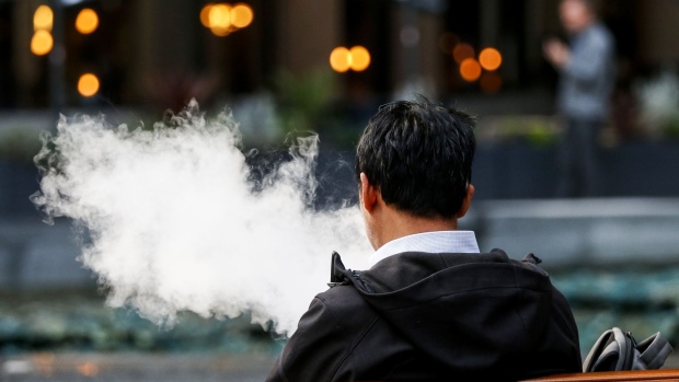 A pedestrian exhales a cloud of vapour from a vape device in London, U.K., on Thursday, Oct. 17, 2019. Photographer: Hollie Adams/Bloomberg