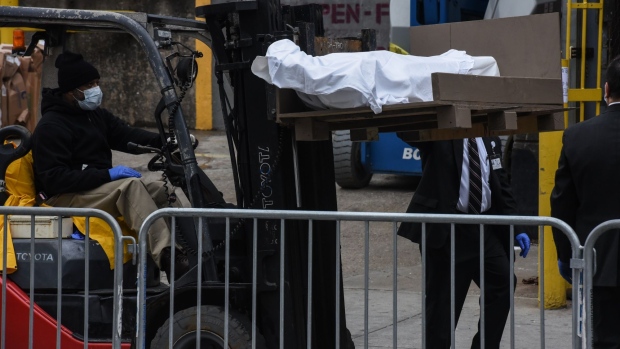 A worker uses a forklift to move a body outside of the Brooklyn Hospital on March 31.