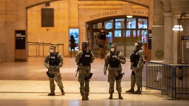 Members of the U.S. Army National Guard wearing protective masks walk through Grand Central Station in New York on April 1. Photographer: Jeenah Moon/Bloomberg