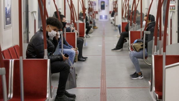 Passengers wearing protective face masks ride the subway during the evening commute in Toronto on March 25. Photographer: Cole Burston/Bloomberg