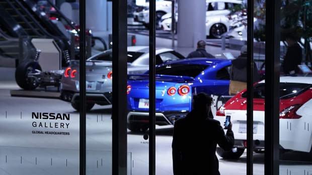 A pedestrian takes a smartphone photograph of Nissan Motor Co. vehicles on display in a showroom at the Nissan Motor Co. headquarters in Yokohama, Japan, on Thursday, Jan. 9, 2020. Nissan’s executives mostly derided attacks by Carlos Ghosn, who lashed out at the automaker he used to lead in a closely watched news conference in Lebanon following his stunning escape from trial in Japan. Photographer: Toru Hanai/Bloomberg
