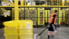 An employee pulls a pallet jack carrying plastic crates past goods in storage units at the Amazon.com Inc. fulfillment center in Robbinsville, New Jersey, U.S., on Thursday, June 7, 2018. Seattle-based Amazon hasn't yet announced the exact date for this year's Amazon Prime Day, the e-commerce giant’s big July sales promotion. Photographer: Bess Adler/Bloomberg
