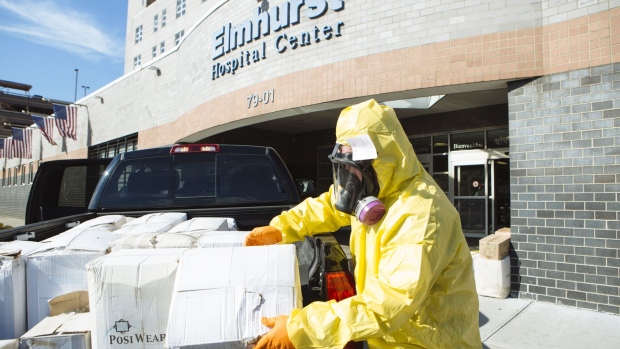 A person wearing protective clothing and a respirator mask donates protective equipment to the Elmhurst Hospital Center in the Queens borough of New York, U.S., on Thursday, March 26, 2020.