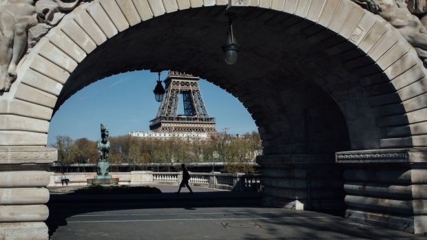 A pedestrian passes the archways of the the Bir Hakeim bridge near the Eiffel Tower in Paris on April 4. Photographer: Cyril Marcilhacy/Bloomberg