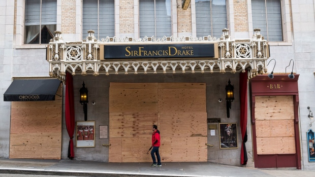 A pedestrian walks past a boarded up St. Francis Drake Hotel in San Francisco. Photographer: David Paul Morris/Bloomberg