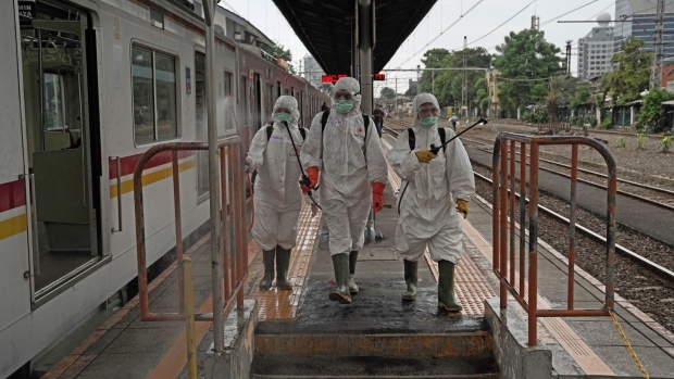 Members of the Indonesian Red Cross Society spray disinfectant on a platform at the Kemayoran train station in Jakarta on March 19. Photographer Dimas Ardian/Bloomberg