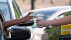 A Starbucks employee hands a customer an order from a drive-thru window at a store in Hercules, California on April 7. Photographer: David Paul Morris/Bloomberg