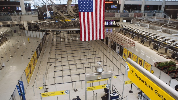 An American flag hangs in Terminal 1 at John F. Kennedy International Airport on April 9. Photographer: Angus Mordant/Bloomberg