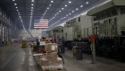An American flag hangs above an assembly line in Fort Worth, Texas. Photographer: Luke Sharrett/Bloomberg