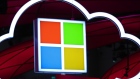 Microsoft Corp. logo, center, hang beside an illuminated iCloud icon at the CeBIT 2017 tech fair in Hannover, Germany. Photographer: Krisztian Bocsi/Bloomberg