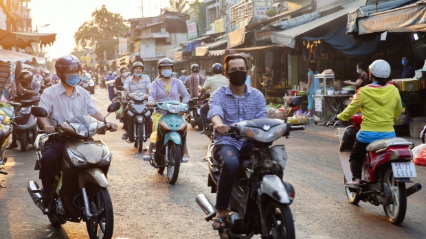 Motorcyclists wearing protective mask ride through Ton That Thuyet market during a partial lockdown imposed due to the coronavirus in Ho Chi Minh city, Vietnam, on Wednesday, April 1, 2020. Prime Minister Nguyen Xuan Phuc ordered a 15-day period of isolation nationwide beginning Wednesday, according to a statement on the government’s website. Residents must stay at home and can only go outside for "essential needs," such as food, medicines, urgent medical services or to go to work at companies permitted by the government to remain open, it said. Photographer: Maika Elan/Bloomberg
