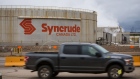 A truck drives past the Syncrude Canada Ltd. facility in the Athabasca oil sands near Fort McMurray, Alberta, Canada, on Sunday, Sept. 9, 2018. New technologies such as driverless trucks and froth-treatments that eliminate the need for multibillion-dollar upgraders -- along with U.S. benchmark crude prices closer to $70 -- are helping make the industry profitable again. Photographer: Ben Nelms/Bloomberg