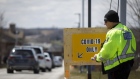 A police officer walks by a drive through Covid-19 testing facility in Orangeville, Ontario