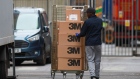 A worker loads boxes, branded with 3M Co. into a truck at The Royal London Hospital, operated by the Barts Health NHS Trust, in London. Photographer: Hollie Adams/Bloomberg