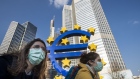 FRANKFURT AM MAIN, GERMANY - MARCH 19: Two students wear face mask while they pass the Euro sculpture with bicycles in the finance district on March 19, 2020 in Frankfurt, Germany. 
