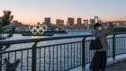 A person takes a photo of floating Olympic rings installed near Odaiba island, Tokyo on March 24.