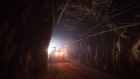 A truck moves through a tunnel to pick up rock ore from the digging floor at the underground gold mine.
