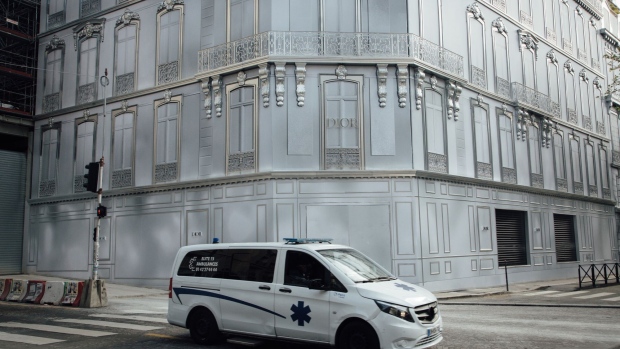 An ambulance passes the Christian Dior SE luxury goods store on Avenue Montaigne. Photographer: Cyril Marcilhacy/Bloomberg