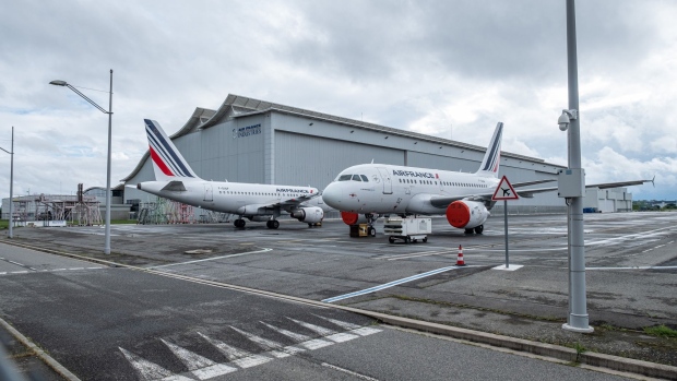 Protective covers sit on the engines of passenger planes, operated by Air France-KLM, as they sit grounded on the tarmac at Blagnac Airport in Toulouse, France, on Monday, April 27, 2020. Airbus chief executive officer Guillaume Faury warned employees that the planemaker is “bleeding cash” and needs to quickly cut costs to adapt to a radically shrinking aerospace industry. Photographer: Balint Porneczi/Bloomberg