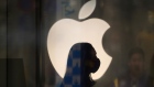 A employee wearing a protective mask is silhouetted while standing in front of an Apple Inc. logo at the company's store, temporarily closed due to the coronavirus, in the Ginza area of Tokyo. Photographer: Toru Hanai/Bloomberg