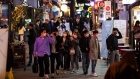 People wearing protective face masks walk through the Itaewon district in Seoul