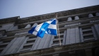 A Quebec flag flies outside the Sun Life building in Montreal, Quebec, Canada, on Monday, Aug. 20, 2018. Median single-family home prices in Montreal rose 5.7% to C$336,250 in July from a year ago, according to the Greater Montreal Real Estate Board (GMREB). Photographer: Brent Lewin/Bloomberg