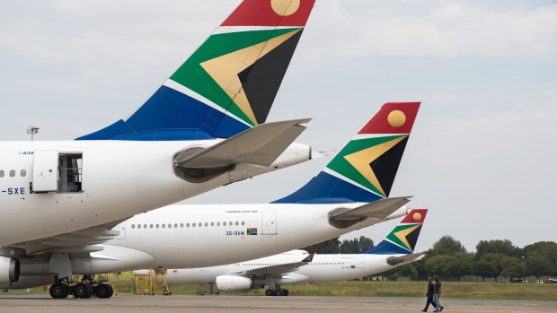 The logo of South African Airways sits on the tailfins of Airbus Group NV A340, left, and A330-200 aircraft parked at O.R. Tambo International airport in Johannesburg, South Africa, on Tuesday, Feb. 24, 2015. South African Airways is close to a 1.25 billion-rand ($107 million) savings target after renegotiating airline leases and supply contracts, canceling two long-haul destinations and reviewing the route of Washington D.C. flights. Photographer: Waldo Swiegers/Bloomberg