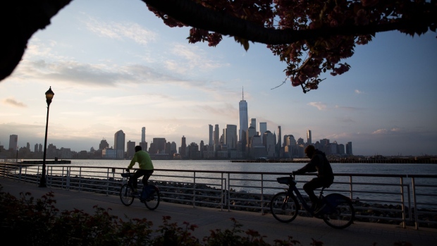 Cyclists pass in front of buildings on the Lower Manhattan skyline along the waterfront in Newport, New Jersey, U.S., on Tuesday, April 21, 2020. Treasury futures ended Tuesday mixed, with front-end yields slightly cheaper on the day and rest of the curve richer, yet off session lows reached during U.S. morning. Photographer: Michael Nagle/Bloomberg