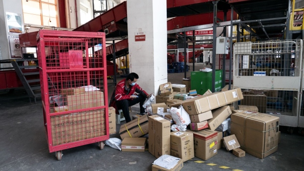 An employee wearing a protective mask sorts through parcels at a JD.com Inc. delivery station in Beijing, China, on Tuesday, April 14, 2020.