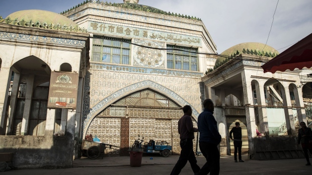 Pedestrians walk past the main bazaar in Kashgar, Xinjiang autonomous region, China. Source: Bloomberg/Bloomberg