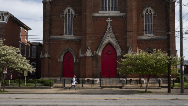 A pedestrian walks past a church in downtown Louisville, Kentucky, U.S., on Saturday, April 25, 2020. Louisville has projected a $115 million budget shortfall over the next 14 months, and without federal aid, will have to cut a fifth of its workforce, according to Louisville Mayor Greg Fischer. Photographer: Stacie Scott/Bloomberg