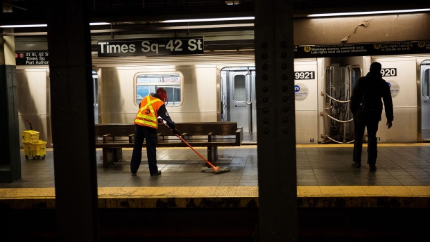 A Metropolitan Transit Authority (MTA) worker mops around a bench at a Times Square subway station in New York on April 21. Photographer: Michael Nagle/Bloomberg