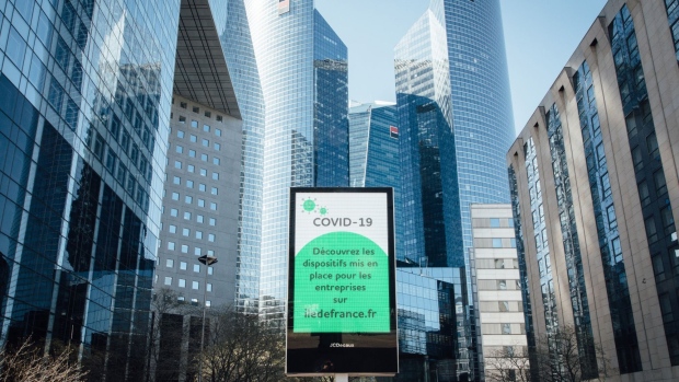 An electronic screen displays coronavirus information outside the Societe Generale SA headquarters, center, and other skyscrapers during citizen movement restrictions and coronavirus containment measures in the La Defense business district in Paris, France, on Tuesday, March 24, 2020. France’s economy is in a record downturn as sweeping measures to contain the coronavirus pandemic shut down businesses and force consumers to stay home. Photographer: Cyril Marcilhacy/Bloomberg