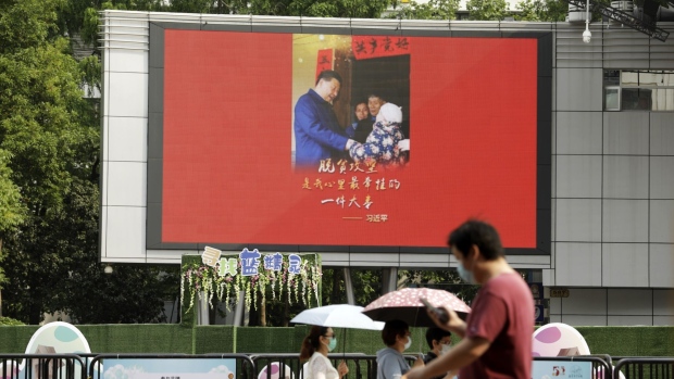 Pedestrians walk past a banner depicting Chinese President Xi Jinping in Shanghai, China, on Thursday, May 28, 2020. Chinese lawmakers approved a proposal for sweeping new national security legislation in Hong Kong, defying a threat by U.S. President Donald Trump to respond strongly to a measure that democracy advocates say will curb essential freedoms in the city. Photographer: Qilai Shen/Bloomberg
