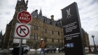 A pedestrian walks past the West Block building of Parliament Hill, the temporary home to the House of Commons, in Ottawa, Ontario, Canada, on Friday, March 13, 2020. Canada's lawmakers are working to tie up loose ends in Ottawa after suspending the House of Commons on Friday, the latest step in the country's efforts to control the spread of the coronavirus. Photographer: David Kawai/Bloomberg